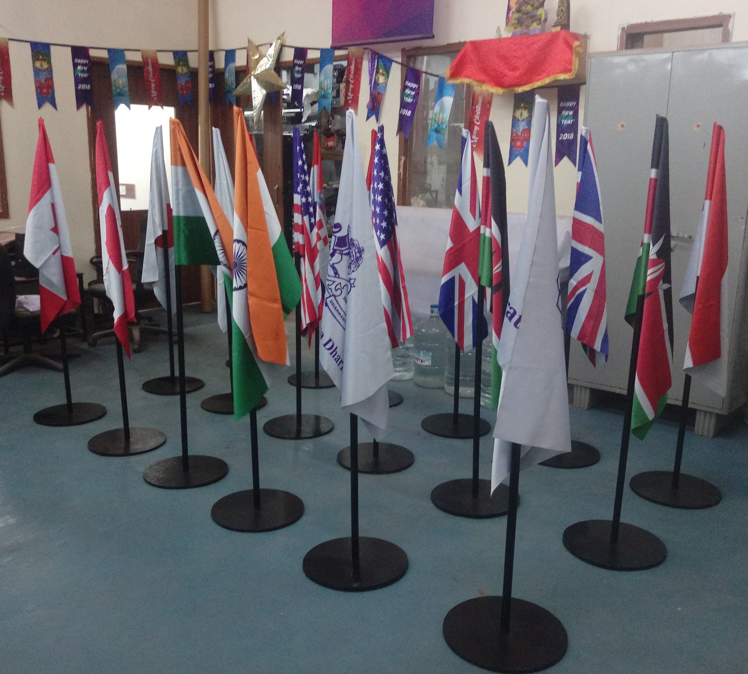 Feather shaped conference flag with vibrant branding displayed at a trade show booth in Dubai with aluminium pole and weighted base
