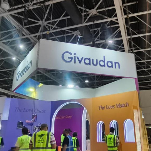 Givaudan corporate blue cutout letters mounted on exhibition booth header fascia at a UAE trade show