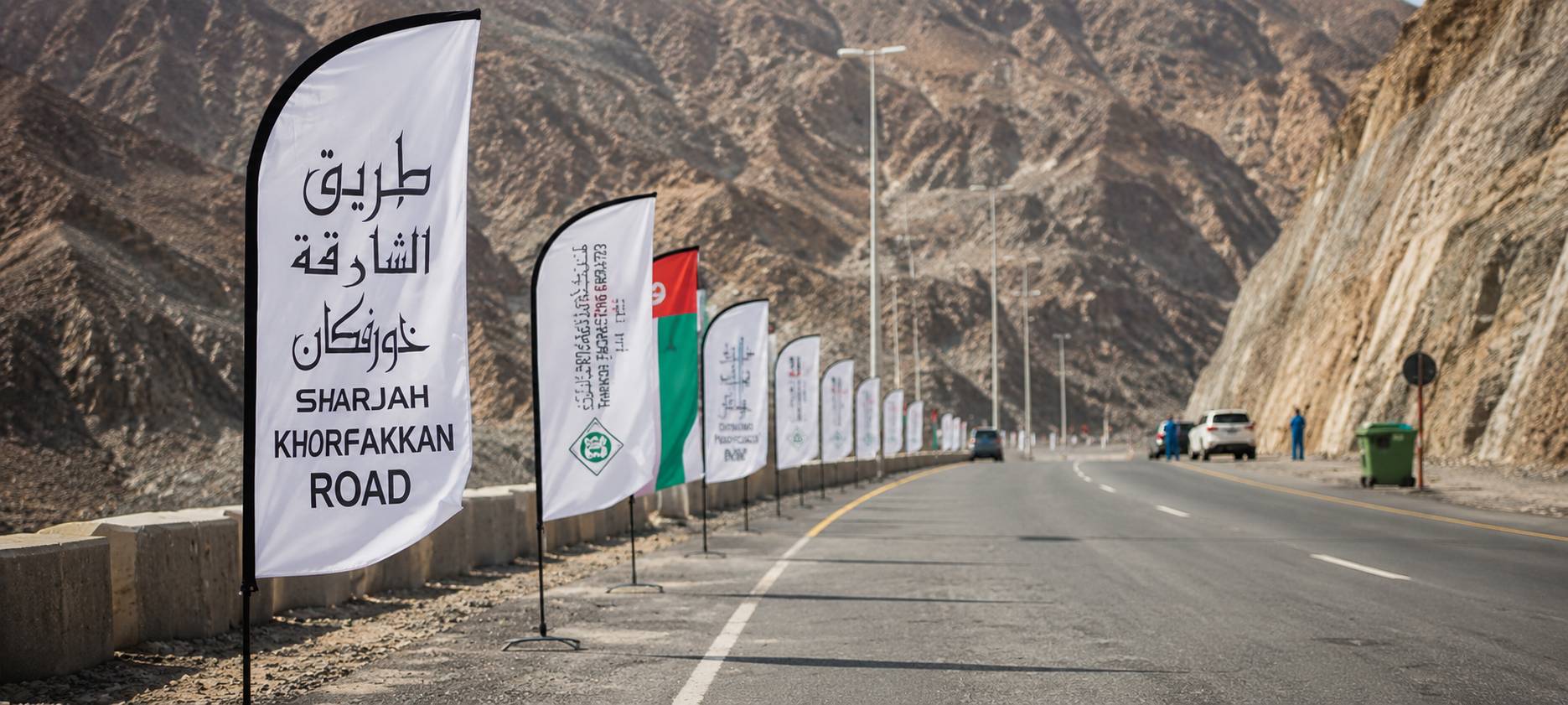 Custom feather shaped sail flag with vibrant branding waving outdoors in the UAE