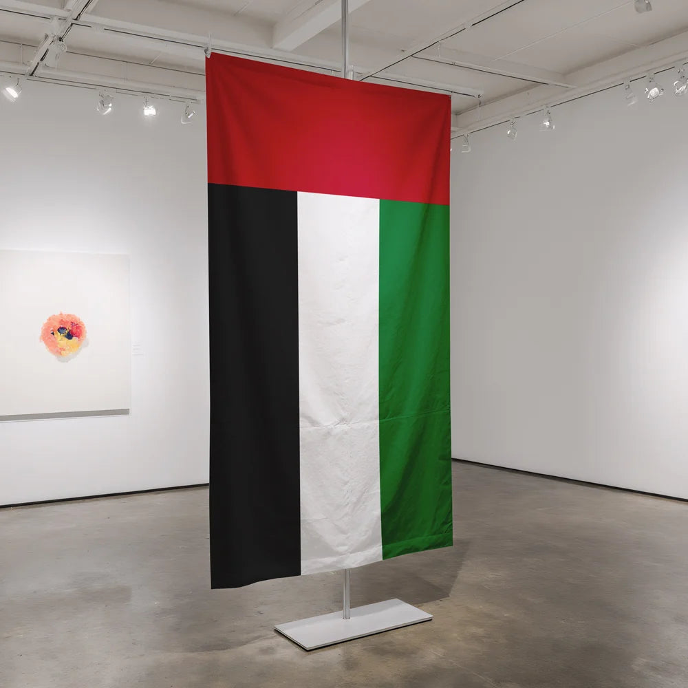 Feather-shaped wall-mounted flag with company branding projecting from a marble lobby wall in a Dubai corporate office